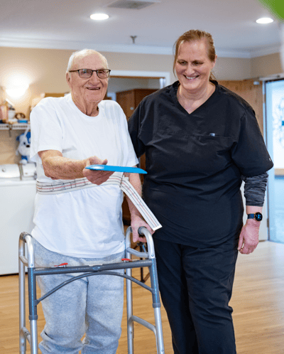 A resident interacting with staff in a care setting