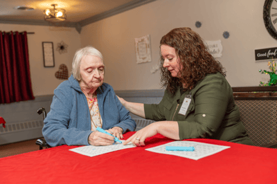 A resident and staff member engaged in a group activity.