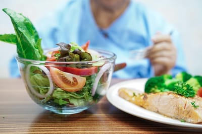 Salad and salmon meal served in a dining area