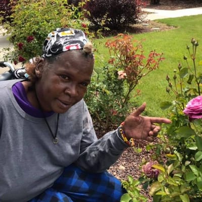 Resident interacting with flowers in a garden area