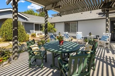 Outdoor seating area with green chairs and a table
