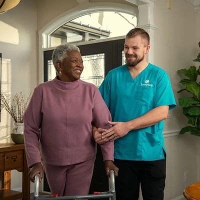 A staff member assisting a resident in a welcoming interior