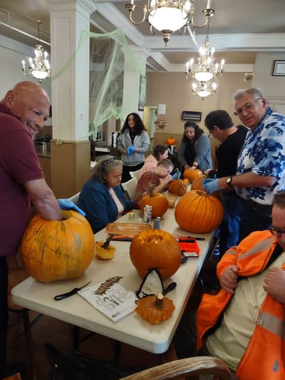 Residents carving pumpkins in a festive activity room