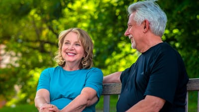 Two residents enjoying a conversation on a bench outdoors
