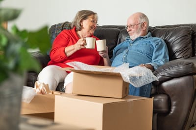 Couple enjoying tea while unpacking boxes