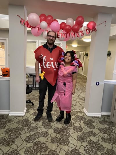 Staff and resident celebrating Valentine's Day in festive attire