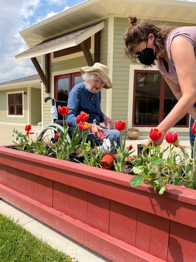 Resident gardening with assistance in flower bed