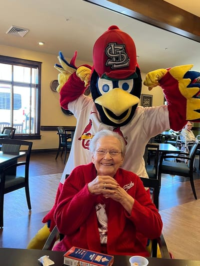 Resident enjoying a visit from a mascot in the common area