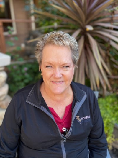 Staff member posing outdoors with plants