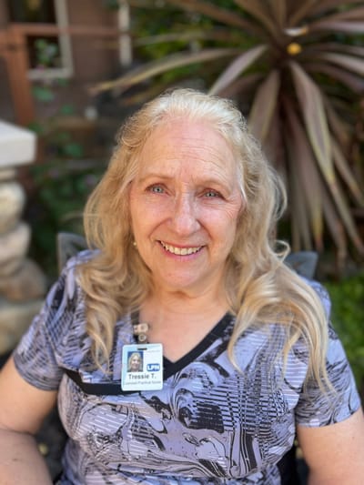 A smiling resident with a name badge outdoors