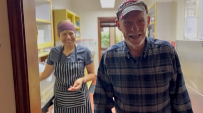 Staff member and resident smiling in a kitchen