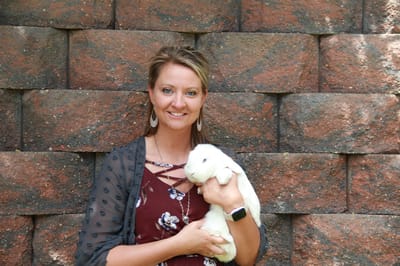 Staff member holding a rabbit outdoors