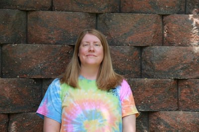 Staff member in a colorful shirt smiling
