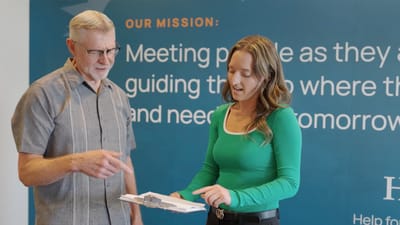 Resident and staff member discussing paperwork indoors