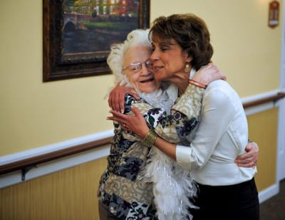 Two residents sharing an affectionate hug indoors