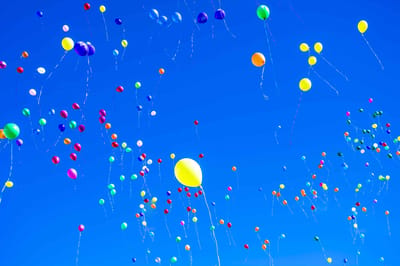 Colorful balloons drifting in a blue sky