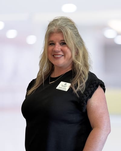 Staff member smiling in a brightly lit facility interior