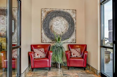 Cozy seating area with red chairs and artwork on the wall