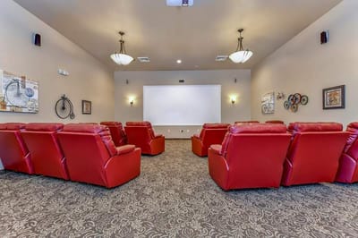 Cozy common area with red reclining chairs and a screen
