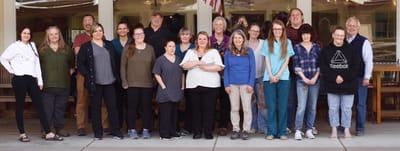 Staff members posing together outside the facility