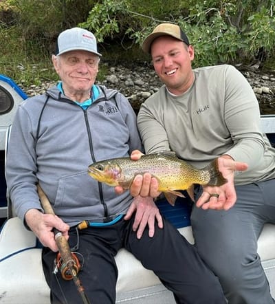 A resident and staff member fishing by the water