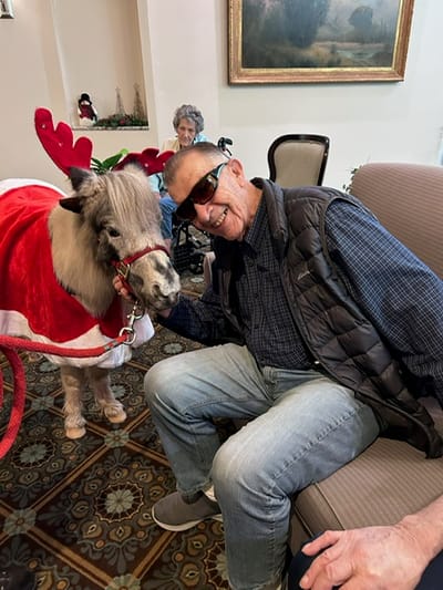 Resident interacting with a miniature horse indoors