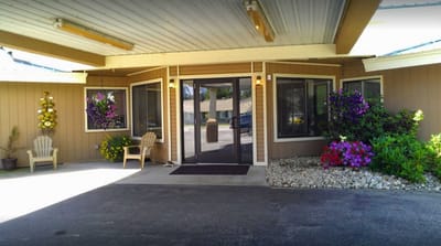 Covered entrance with flowers and seating area
