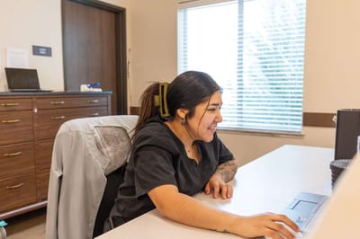 A staff member working at a desk in a facility office