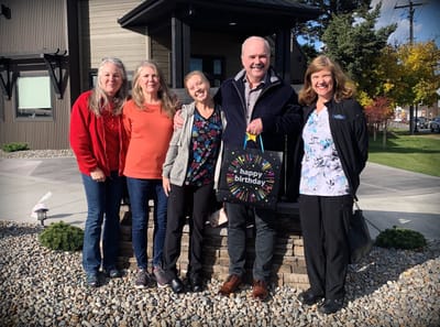 Staff and residents celebrating a birthday outside the facility