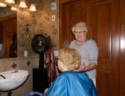 Staff assisting a resident in a beauty salon