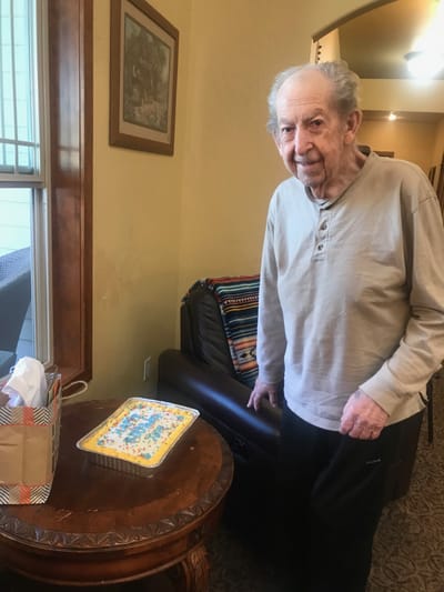Happy resident with a cake in a common area