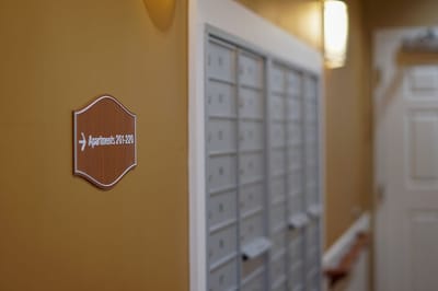 Interior hallway with mailbox area and sign.