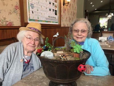Two residents enjoying a craft project indoors