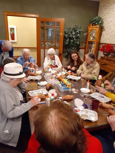 Residents engaging in a crafting activity around a table