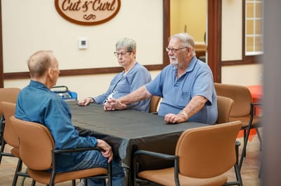 Residents engaged in conversation at a common area table
