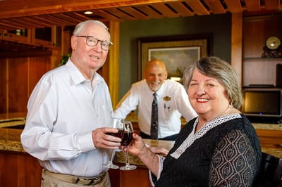 Residents toasting with drinks in a warm interior space