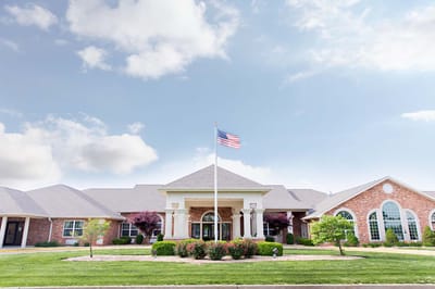 Exterior view of a senior living facility with garden