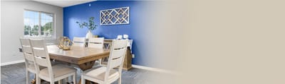 Bright dining room with a wooden table and blue wall