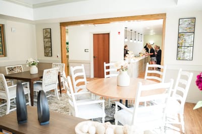 Bright common area with tables and residents