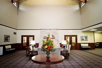 A bright lobby area with seating and floral arrangement