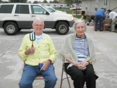 Two residents enjoying time outdoors with gardening tools