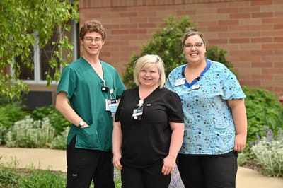 Three staff members posing outside the facility