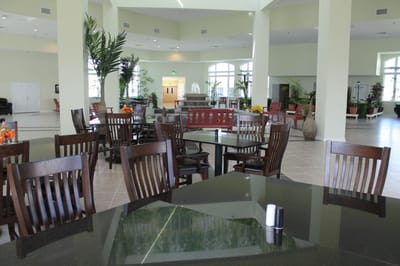 Sunshine Gardens, assisted living in Marion, IL — Bright dining area with wooden chairs and tropical plants