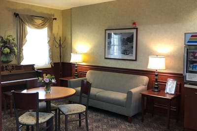 Cozy common area with seating, flowers, and piano