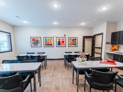 Bright activity room with tables and artwork on the walls