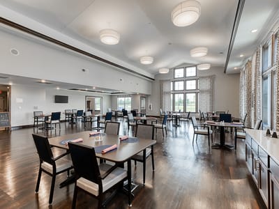Dining room with tables and chairs set up for residents
