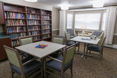 Bright common area with bookshelves and puzzle tables