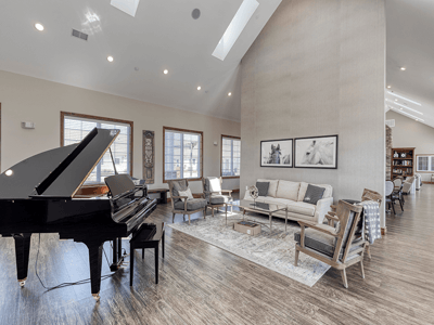 Bright common area with piano and cozy seating