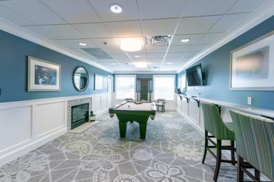 A bright common area with a pool table and seating