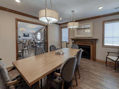 Dining area with a large wooden table and modern lighting